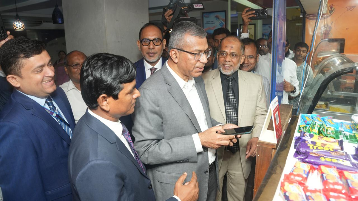 বাংলা কিউআর ব্যবহার করে কেনাকাটা করে দেখাচ্ছেন গভর্নর মোস্তাকুর রহমান। ছবি: সংগৃহীত