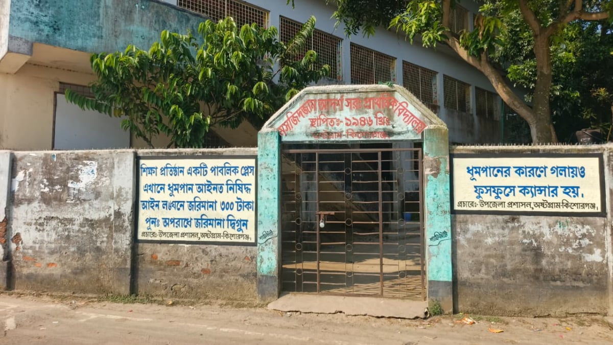 মঙ্গলবার দুপুরে স্কুলটির প্রধান ফটকে তালা ঝুলতে দেখা গেছে। ছবি: রাজনীতি ডটকম