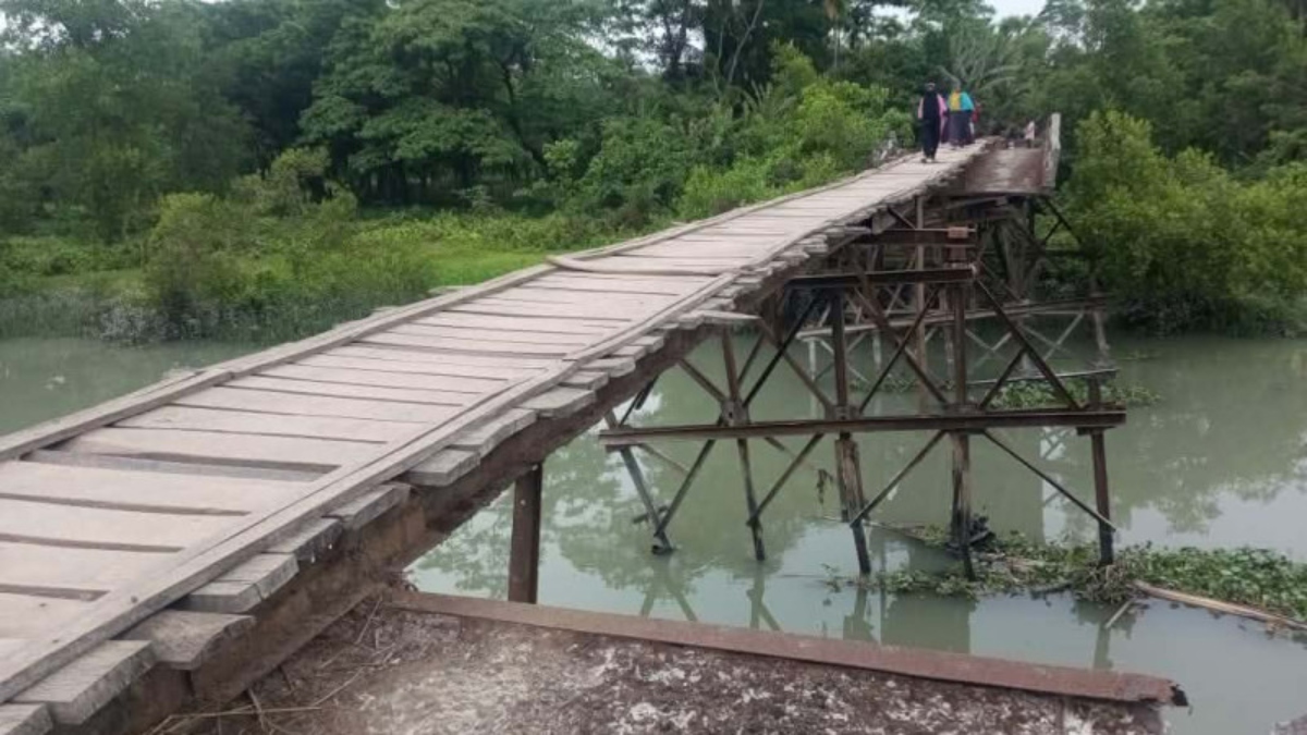 স্থানীয়রা নিজেরাই কাঠের পাটাতন বসিয়ে চলাচলের ব্যবস্থা করেছেন। ছবি: রাজনীতি ডটকম