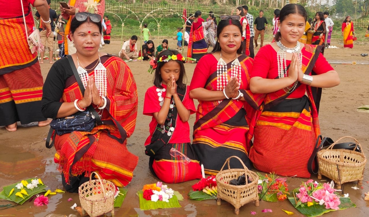 ঐতিহ্যবাহী রিনাই-রিসা পোশাকে সজ্জিত হয়ে ত্রিপুরা নারীরা বন থেকে সংগ্রহ করা নানা ফুল দিয়ে দেবী গঙ্গার পূজা করেন। ছবি: রাজনীতি ডটকম