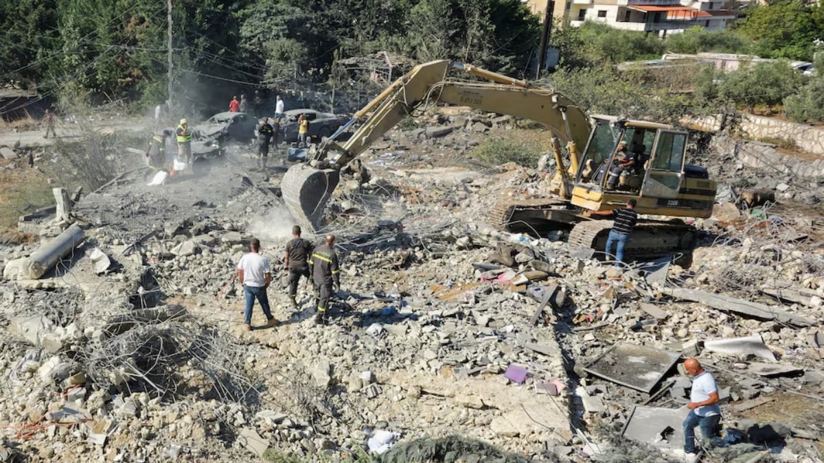 লেবাননে ইসরায়েলি হামলার ঘটনাস্থলে ভারী যন্ত্রপাতি দিয়ে ধ্বংসস্তূপ সরানোর কাজ চলছে। ছবি: রয়টার্স
