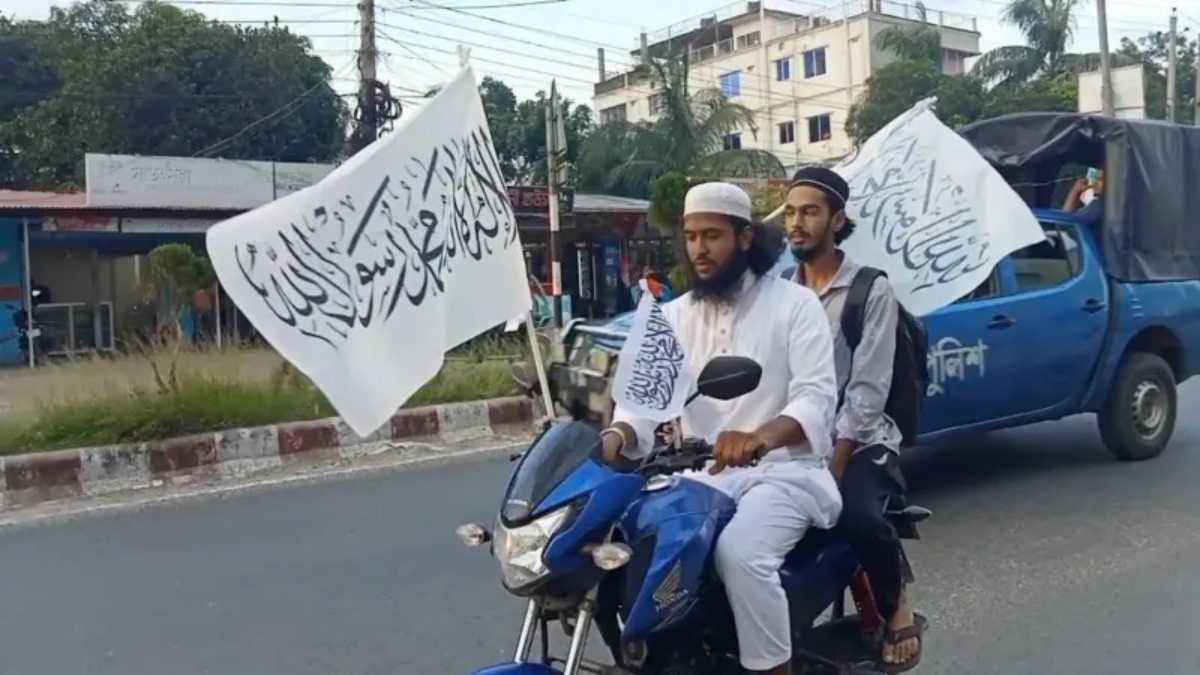 মাদারীপুরে কালেমা খচিত পতাকা নিয়ে মিছিলে যাচ্ছেন দুই যুবক। ছবি: সংগৃহীত