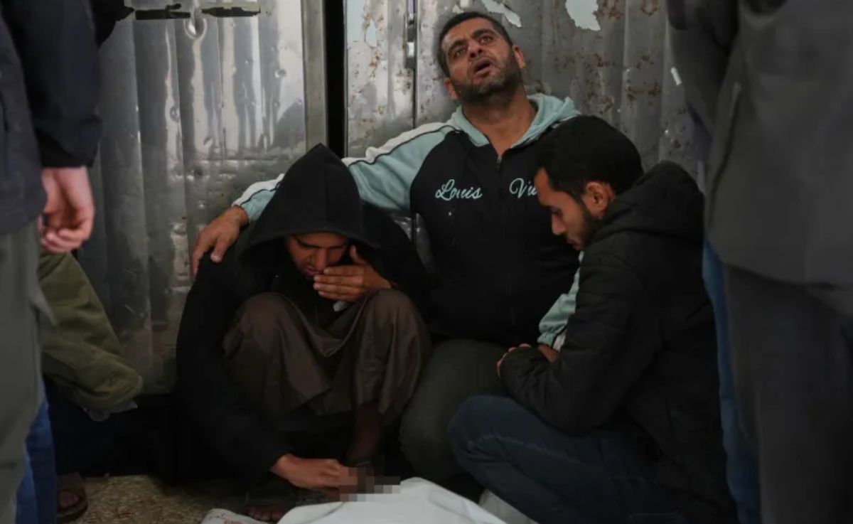 Palestinians mourn over the bodies of people killed in an Israeli strike in Bureij refugee camp