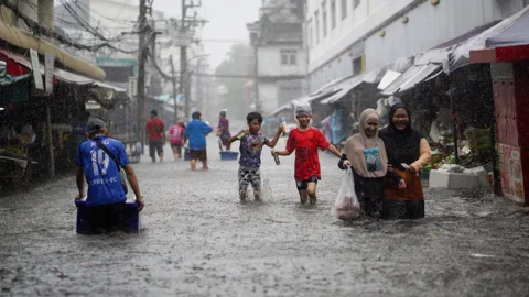 ভারী বৃষ্টির মধ্যে থাইল্যান্ডের ব্যাংককের একটি বাজারে বন্যার পানির মধ্য দিয়ে চলাচল করছেন স্থানীয় বাসিন্দারা। ২৮ সেপ্টেম্বর ২০২৬। ছবি: রয়টার্স