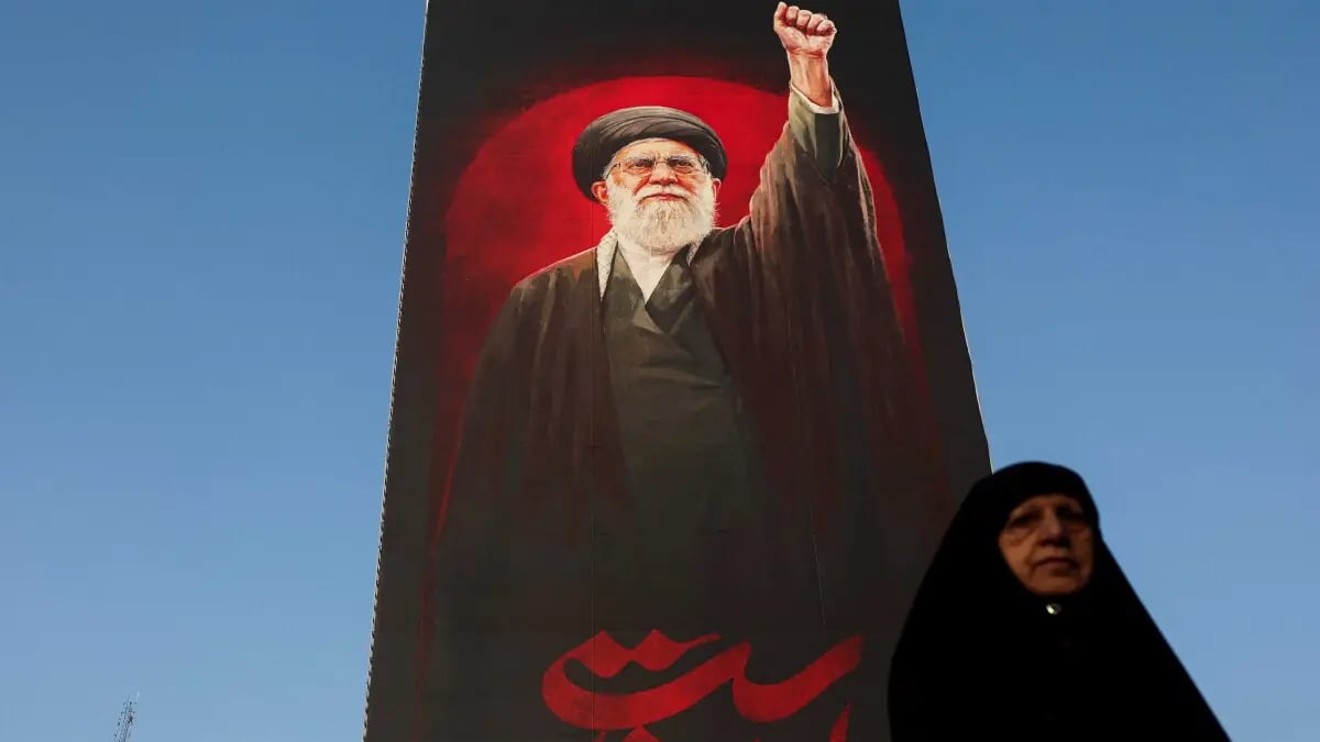 Woman-In-Front-Of-Photo-Of-Ayatollah-Ali-Khamenei-In-Tehran-16-08-2026