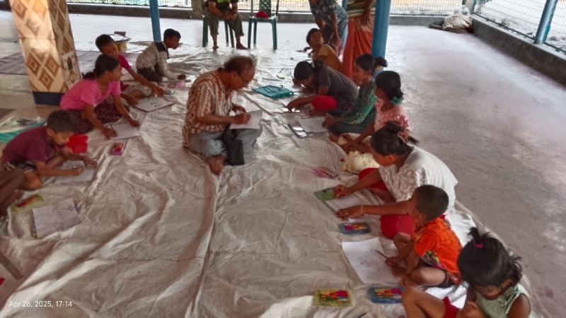 গ্রামের মন্দির চত্বরে শিশু মাদুর বিছানো মেঝেতে বসে ছবি আঁকছে। পাশে বসে শিশুদের ছবি আঁকার কায়দা-কানুন শেখাচ্ছেন বিমানেষ বিশ্বাস।